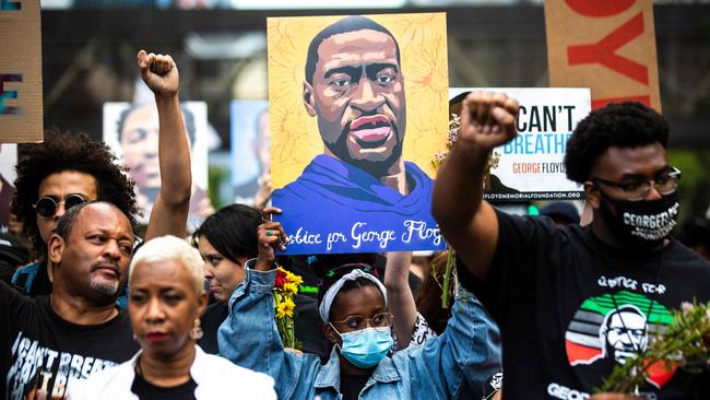 People raise their fists as they march during an event in remembrance of George Floyd in Minneapolis, Minnesota.