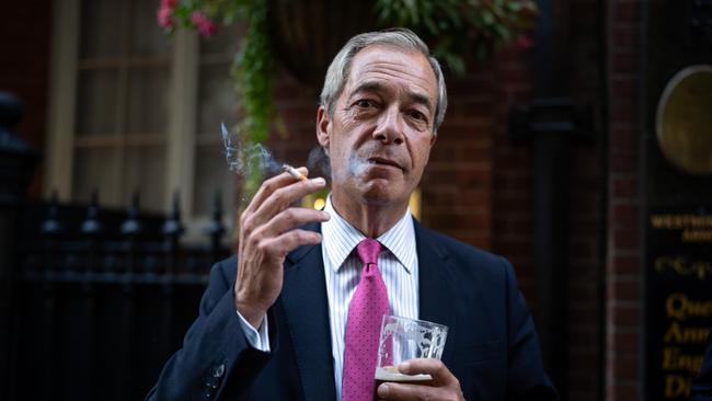 Reform UK leader Nigel Farage smokes a cigarette and drinks a pint of ale outside a pub on August 29, 2024 in London, England. Picture: Getty