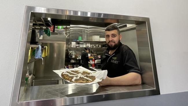 Matthew Hanna displays one of the Lebanese pizzas at Cedary Bakehouse.