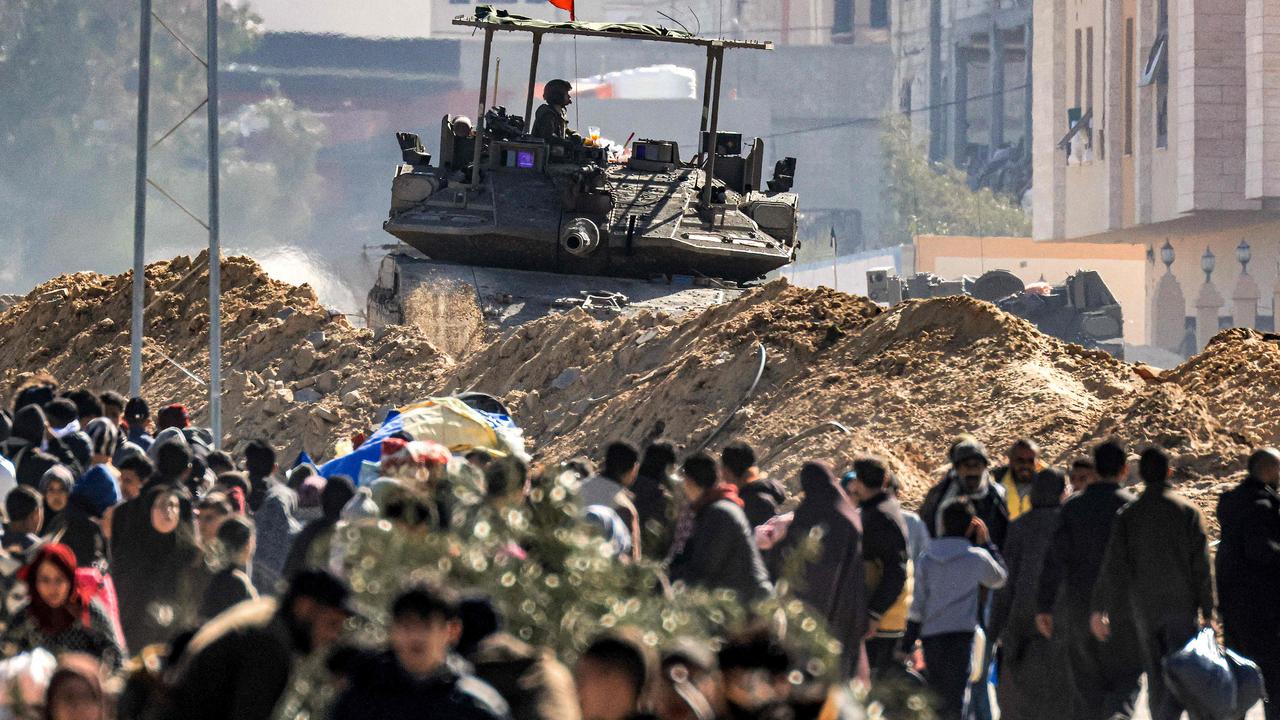 An Israeli battle tank is deployed to guard a position as displaced Palestinians flee from Khan Yunis in the southern Gaza Strip. Picture: AFP