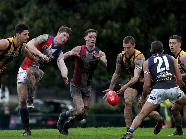 Players square off for old-fashioned wet-weather football at City Oval.