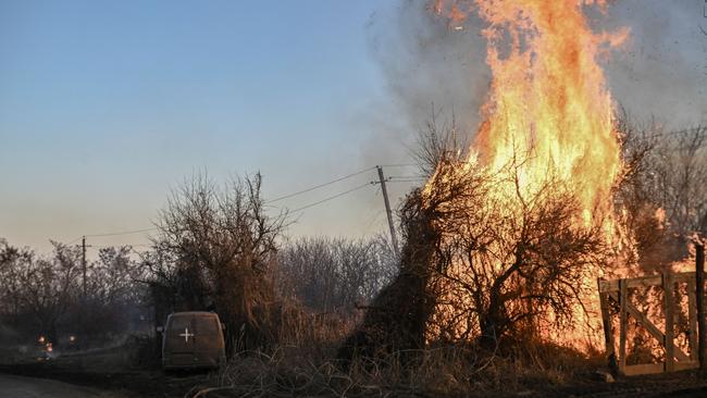 Trees burn next to a Ukrainian military vehicle, after white phosphorus munitions exploded in the air, at the village of Chasiv Yar near Bakhmut. Picture: AFP