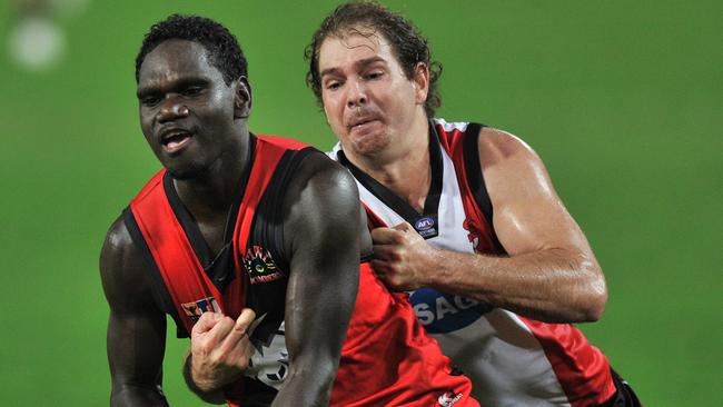 Edward Darcy of Tiwi Bombers (left) tries to pass the ball as Shannon Rusca of Southern Districts tries to tackle from behind during round 11 of the NTFL match played at the TIO stadium.