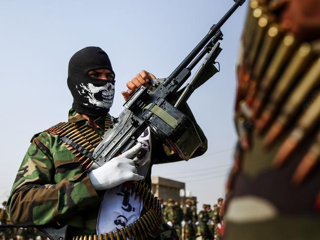 TOPSHOT - A picture taken on September 16, 2017 shows masked members of the Imam Ali Division, one of the groups fighting within the Hashed al-Shaabi (Popular Mobilisation) paramilitaries, marching with machine guns in a military parade in the holy shrine city of Najaf in central Iraq. / AFP PHOTO / Haidar HAMDANI