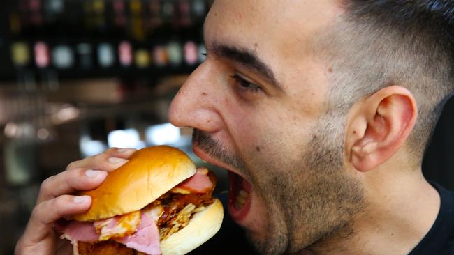 Chef Julian Cincotta takes a bite from one of his world famous Butter 300 sandwich in his Parramatta restaurant Butter on Marsden St. (AAP Image / Angelo Velardo)