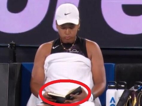 Naomi Osaka reads journal mid game