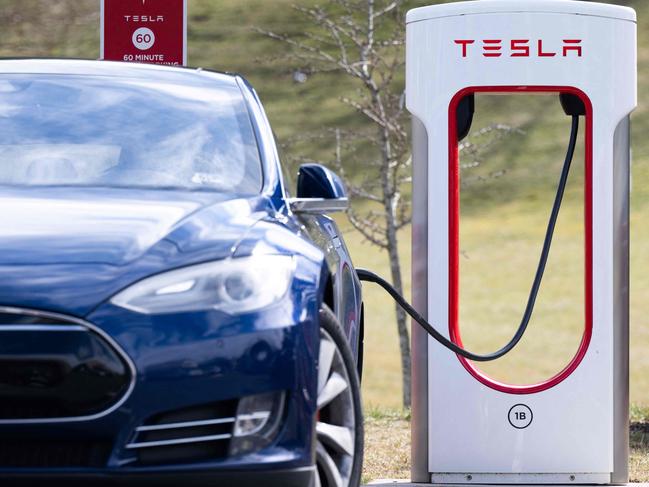 (FILES) A Tesla Model S sedan is plugged into a Tesla Supercharger electrical vehicle charging station in Falls Church, Virginia, February 13, 2023. Tesla will open its network of superchargers in the United States and Canada to Ford electric vehicles from 2024, the companies said Thursday, doubling the stations available to Ford customers. (Photo by SAUL LOEB / AFP)