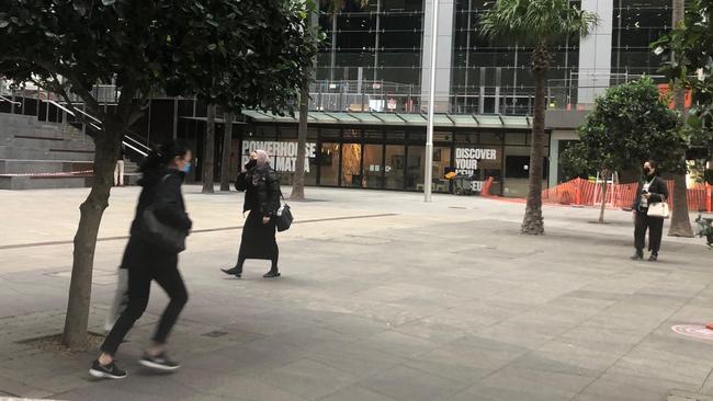 A young woman races through Parramatta Square on her way to the train station.