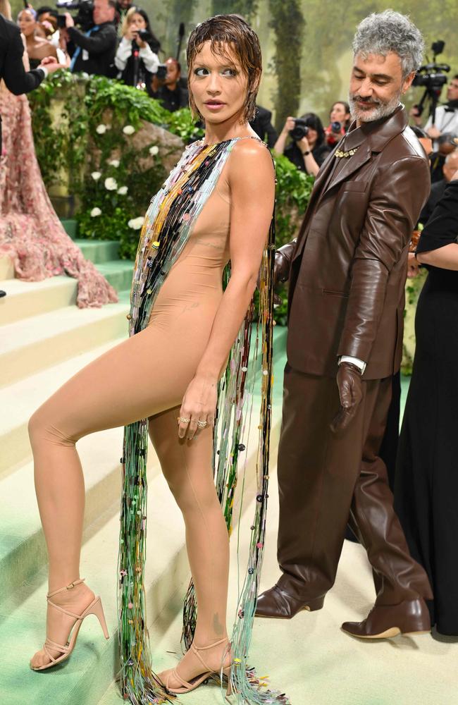 Taika Waititi checks out his wife, Rita Ora, as she poses for photos on the steps at the Metropolitan Museum of Art for the Met Gala. Picture: Angela Weiss/AFP