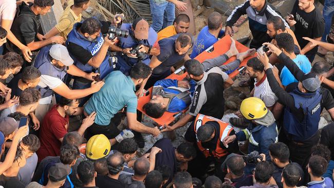 Palestinians carry a youth injured during an Israeli airstrike in Khan Yunis in the southern of Gaza Strip, on Monday. Picture: AFP