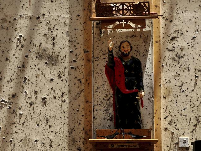 A statue of St. James stands on a wall speckled with fragments of shrapnel at St. Sebastian's Church, where a suicide bomber blew himself up in Negombo, north of Colombo. Picture: AP