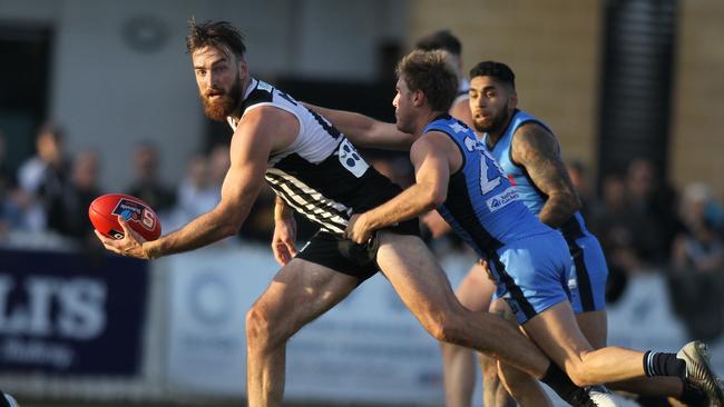 Port's Charlie Dixon looks to handball under pressure from Sturt and former Power player Sam Colquhoun at Alberton Oval on Saturday. Picture: AAP Image/Dean Martin