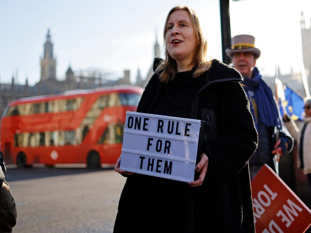 Demonstrators hold placards as they protest near the House of Commons, where Boris Johnson apologised over a party scandal. Picture: AFP