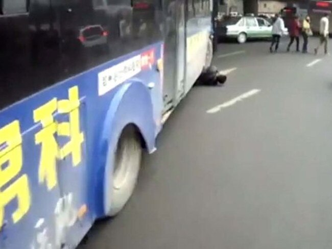 Hit and trapped ... Pedestrian Chang Suibin is stuck underneath the bus' front wheel in the Chinese city of Zhengzhou. Picture: CCTV+ / YouTube