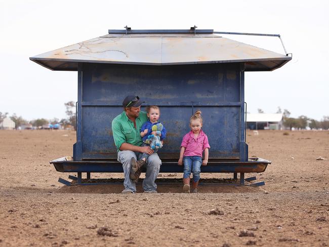 Peter Holcombe, 32, with his daughter Eve, 3, and son Finn, 2, at their dry farm near Walgett. Picture: Sam Ruttyn