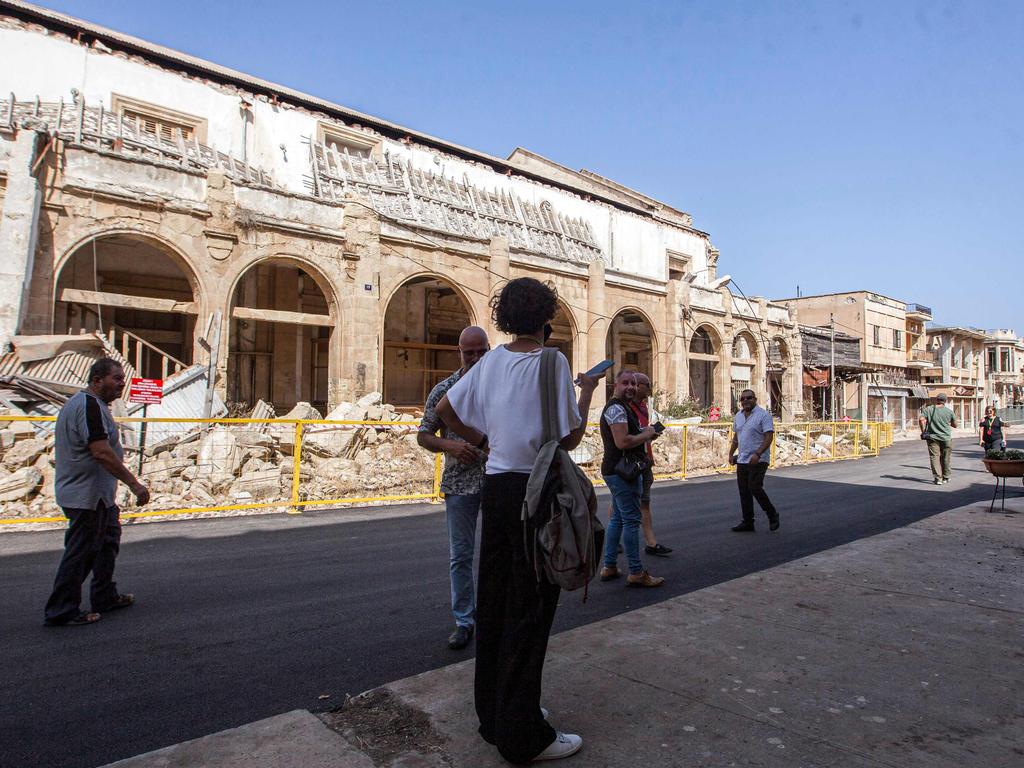 Visitors inspect the decaying buildings of the abandoned resort. Picture: Birol Bebek / AFP