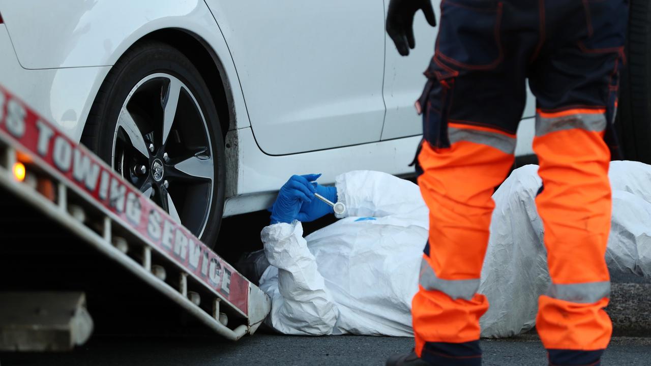 A forensic investigator examines a car linked to Hall’s death.