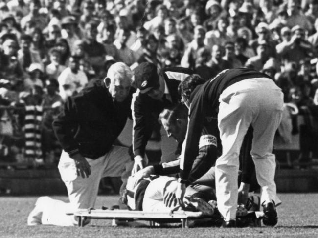 Trainers lift injured Kym Kinnear onto a stretcher. SANFL football - Port Adelaide vs Glenelg Grand Final match at Football Park 24 Sep 1977. (Pic by staff photographer Bryan Charlton)