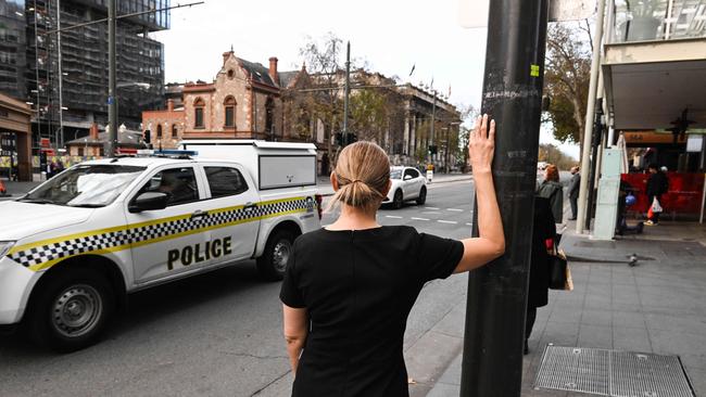 Local business manager Virginia Iommazzo observes police at the Railway Station precinct of North Tce. Picture: Brenton Edwards