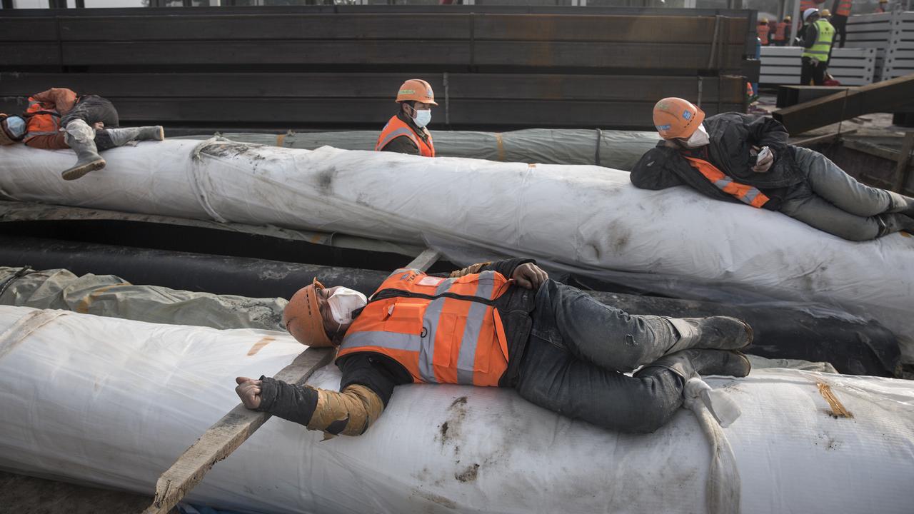 Construction workers rest on building materials as new hospitals are built to tackle the coronavirus on January 28. Picture: Getty Images