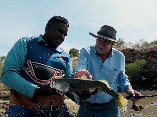 Charles Wooley and his Indigenous fishing guide Sam Birch inspect their prize ‘barra’ catch.