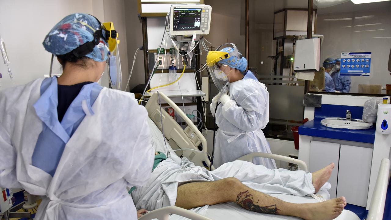 Female health workers wearing personal protective equipments (PPE) get ready to treat and check the heart beat of a male patient with COVID-19 in the Intensive Care Unit at de La Samaritana University Hospital on August 28, 2020 in Bogota, Colombia. Picture: Guillermo Legaria/Getty Images