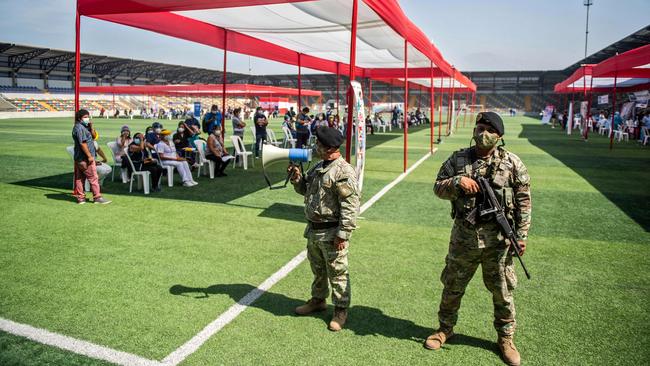 Soldiers stand guard at a health workers vaccination campaign with the vaccine developed by Sinopharm in Ollantaytambo stadium in Lima, Peru. Picture: AFP