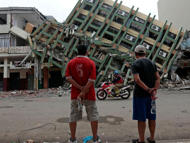 Men look at a destroyed building in the town of Portoviejo, Ecuador, on April 21, 2016 almost a week after a powerful quake hit the country. Picture: AFP PHOTO / Juan Cevallos
