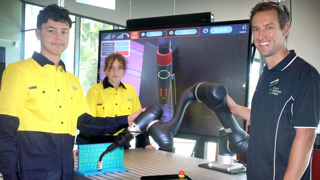 Findon Technical College lead of advanced manufacturing Joel Phillips with students Atticus Ware, 14, and Isla Taylor, 14 and a robotic welding arm. Picture: Dean Martin