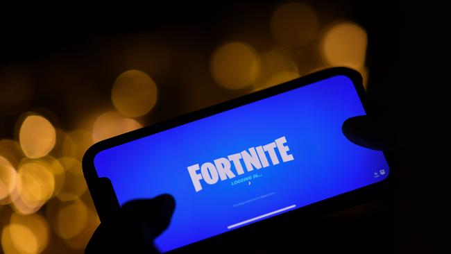 A person logging into Epic Games' Fortnite on their smartphone in Los Angeles (Photo by Chris DELMAS / AFP)