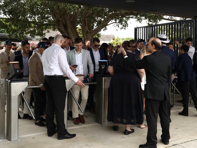 Racegoers wait at the turnstiles prior to Sydney Racing