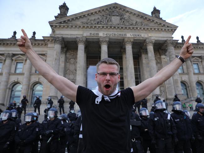 A demonstrator stands in front of riot police in Berlin in a protest against coronavirus-related restrictions and government policy. Picture: Getty Images