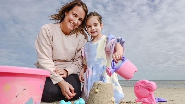 Sallie Spicer with her daughter Mollie enjoying the warmer weather at Henley Beach ahead of the deluge. Picture: NCA NewsWire / Brenton Edwards