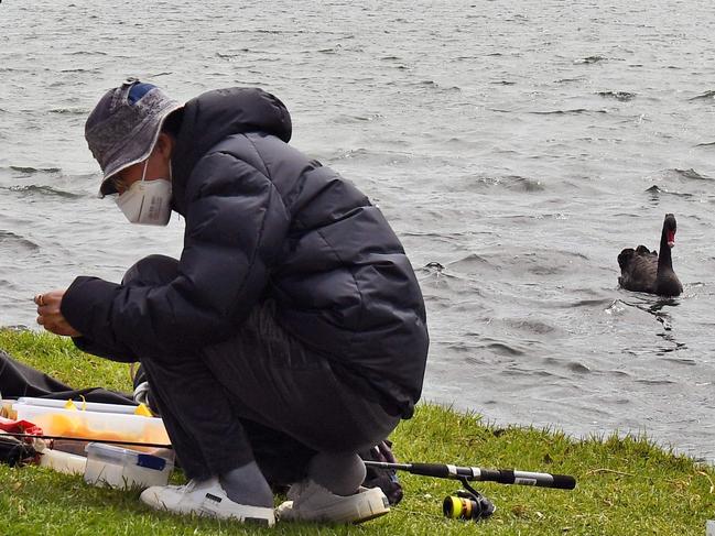 People fish on Melbourne's Albert Park Lake on October 12, 2020, as they use their two hours daily exercise allowed during the stage four restrictions due to the COVID-19 coronavirus outbreak. (Photo by William WEST / AFP)