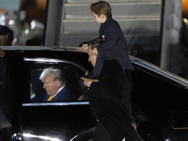 Elon Musk carries his son as they arrives on Air Force One with President Donald Trump at Miami International Airport in April. Picture: AP Photo
