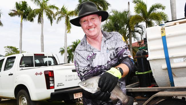 Minister for Primary Industry and Resources Paul Kirby with one of the barra set to be released into the Palmerston lakes. Picture: Katrina Bridgeford