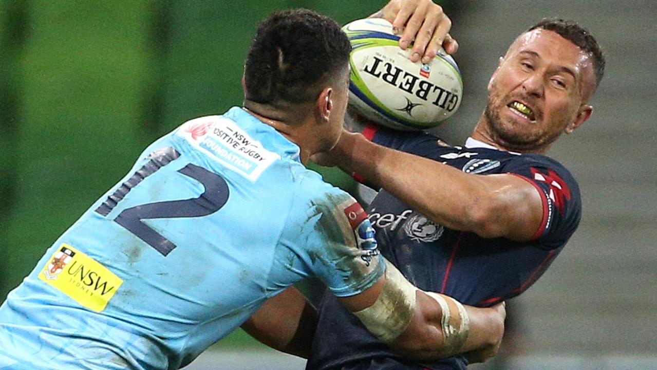 Quade Cooper of the Rebels is tackled by Lalakai Foketi of the Waratahs.