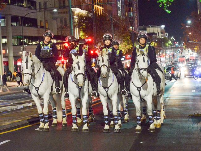 Police horses watch a protest rally walk along King William St protesting against anti protesting laws. Picture: Brenton Edwards