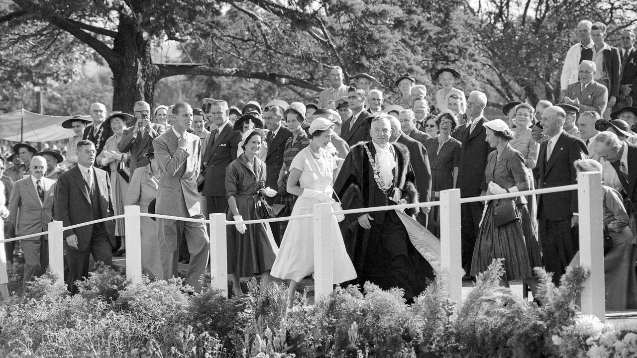 Toowoomba's mayor, Alderman Anderson, escorts the official dais Queen Elizabeth for the Queen's welcome at Queen's Park. Following is the Duke of Edinburgh Prince Phillip, Mrs Anderson, Transport Minister Mr J. Duggan and Mrs Duggan.