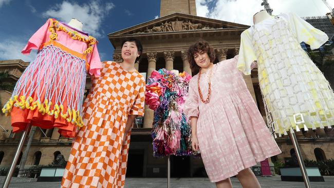 Fashion designer Ivy Niu and artist Bianca Mavrick with dresses that will be displayed in an exhibition during the Brisbane Art Design festival at Brisbane City Hall. Picture: Liam Kidston.