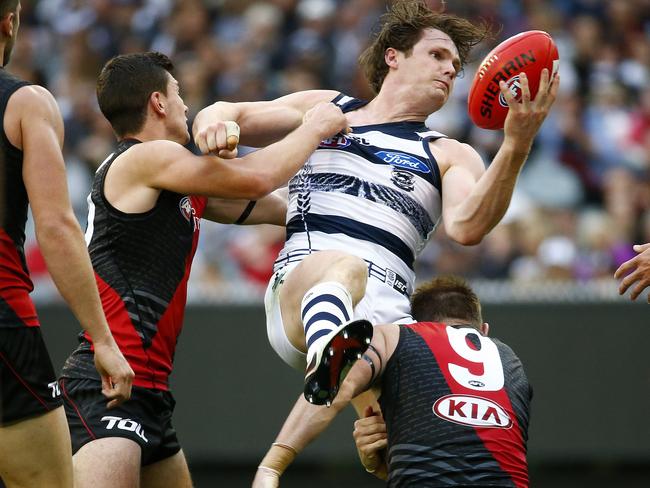 Patrick Dangerfield fires a handball away despite a strong tackle from Brendon Goddard. Picture: Colleen Petch.