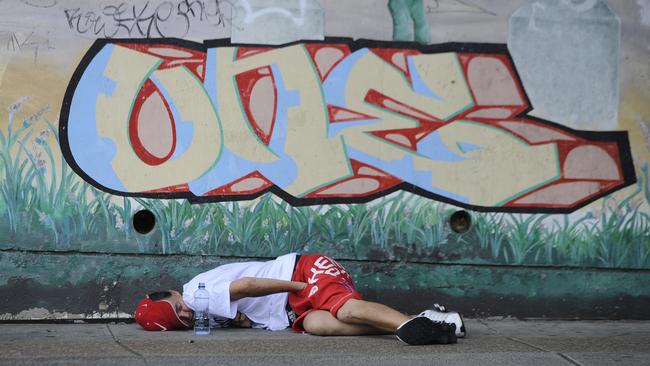 A junkie sleeps on the pavement of Railway Terrace, Cabramatta.