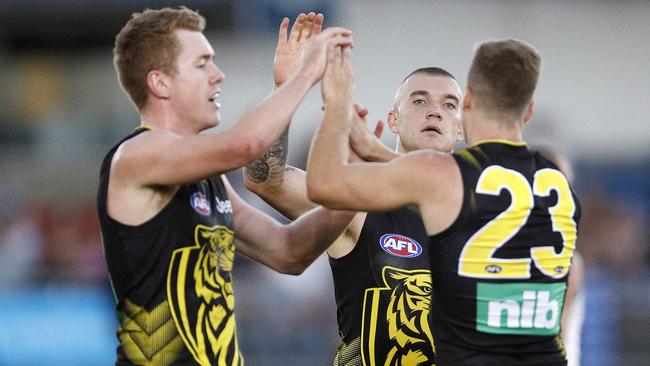 Jacob Townsend, Kane Lambert and Dustin Martin celebrate a goal.