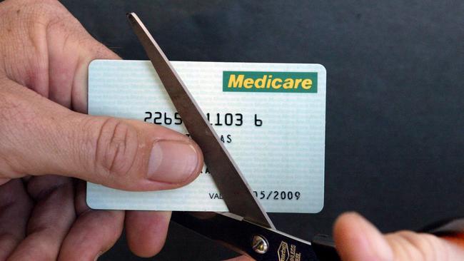 APRIL 28, 2003: Generic photo of cutting up Medicare card with pair of scissors, 28/04/03. Pic Jeff Darmanin.