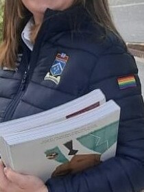 The pride flag is on the left arm.