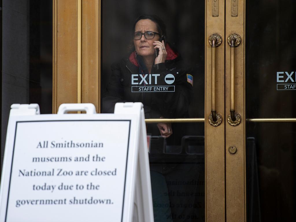 A US government employee talks on the phone as she looks out of a closed Smithsonian museum in Washington, DC. Picture: AFP