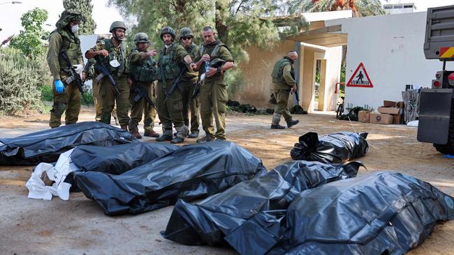 Israeli soldiers prepare to remove the bodies of their compatriots, killed during an attack by the Palestinian militants, in Kfar Aza. Picture: AFP