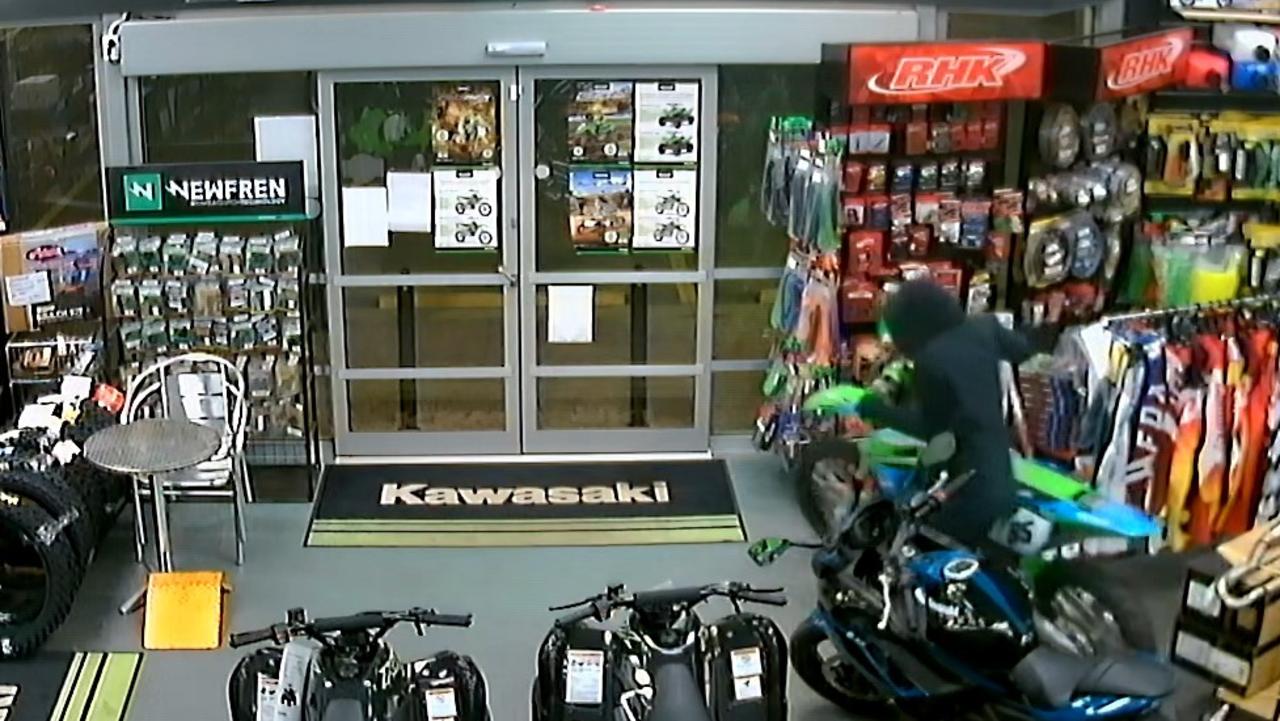 A thief wearing shorts, thongs, gloves and a balaclava smashed into Mackay Kawasaki and stole a bike awaiting pick up from its new owner.