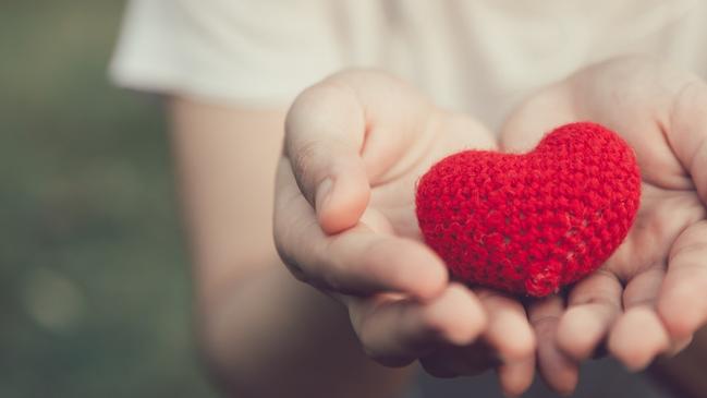 SHWE 0310 Ali Black iStock-927461270 Sharing Love and Heart red color on women hand in valentine's day vintage color tone