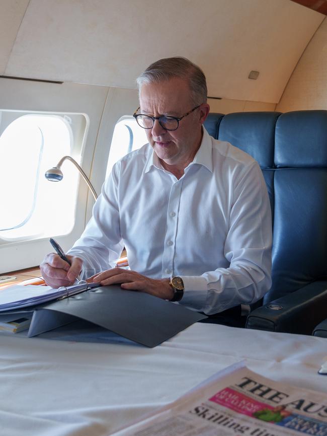 Albanese flicks through his briefing folders, asking questions and taking notes.